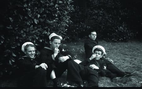 Sailors resting on a grassy bank while on leave