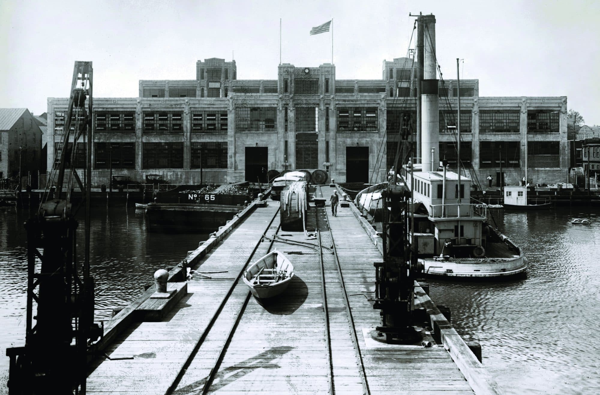 A river dock and terminal building with the American flag flying above it